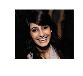 A dark-haired woman smiles at the camera, laughing